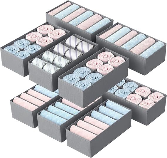 Grey fabric drawer organisers with rolled clothes in each slot